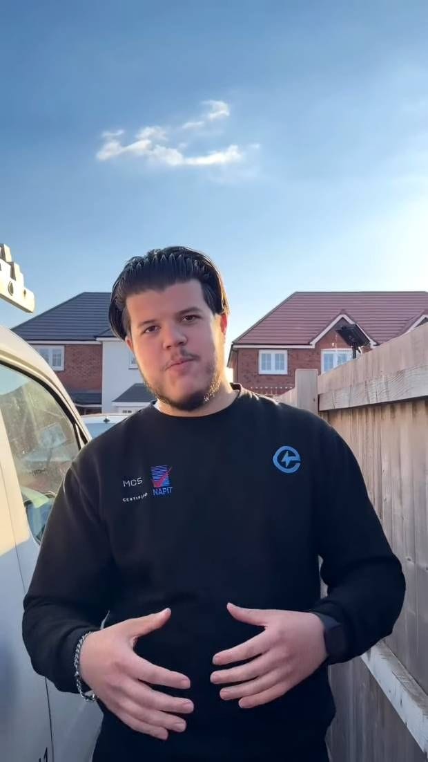 Andre beside the van in low afternoon sun, in an Electrifyd sweatshirt